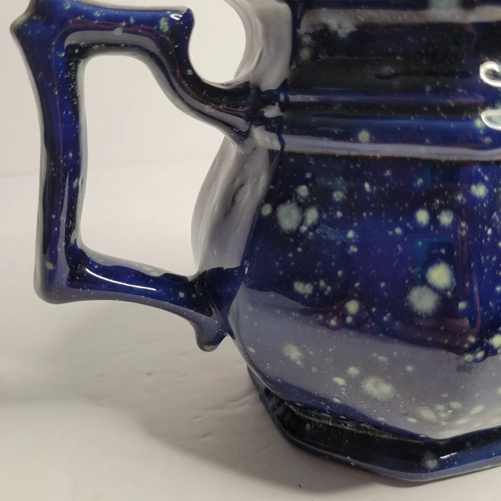 A blue and white speckled teapot. 271
